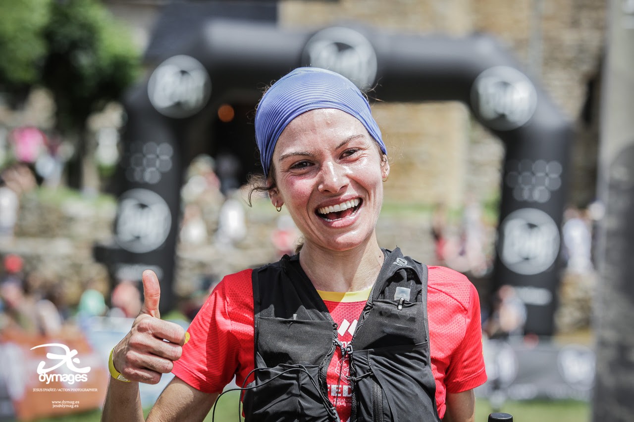 Una competidora del mundial de carreras por montaña sonríe en su llegada a la meta
